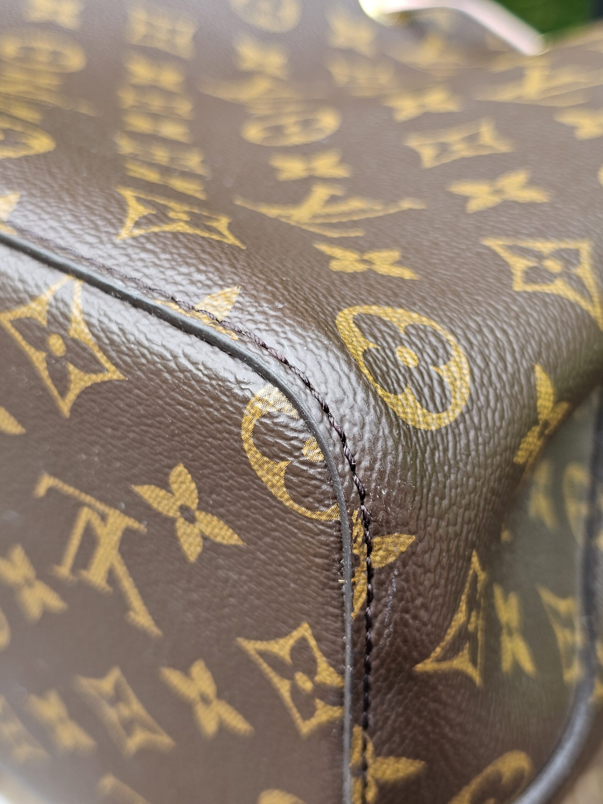 Side seam and Monogram canvas of the Louis Vuitton NeoNoe MM bucket bag