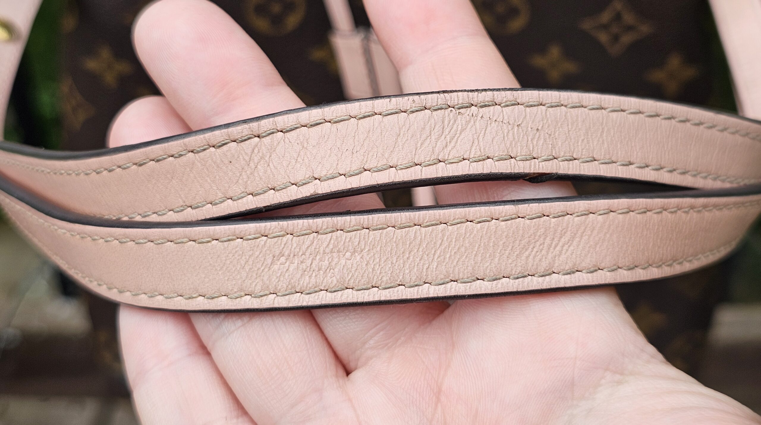 Rose Poudre leather shoulder strap of the Louis Vuitton NeoNoe MM showing wear and glazing loss