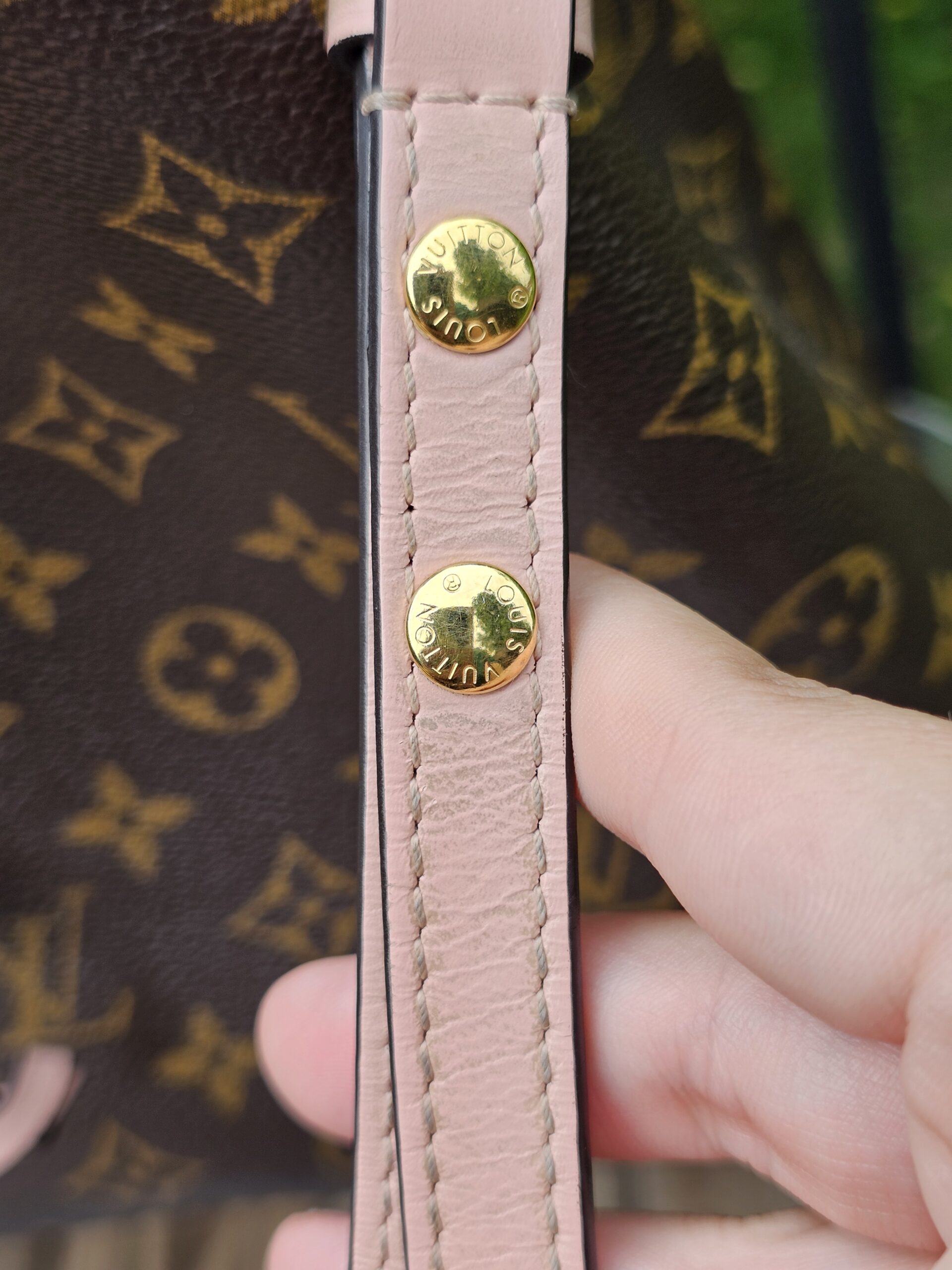 Gold-tone studs on the Rose Poudre leather trim of the Louis Vuitton NeoNoe MM