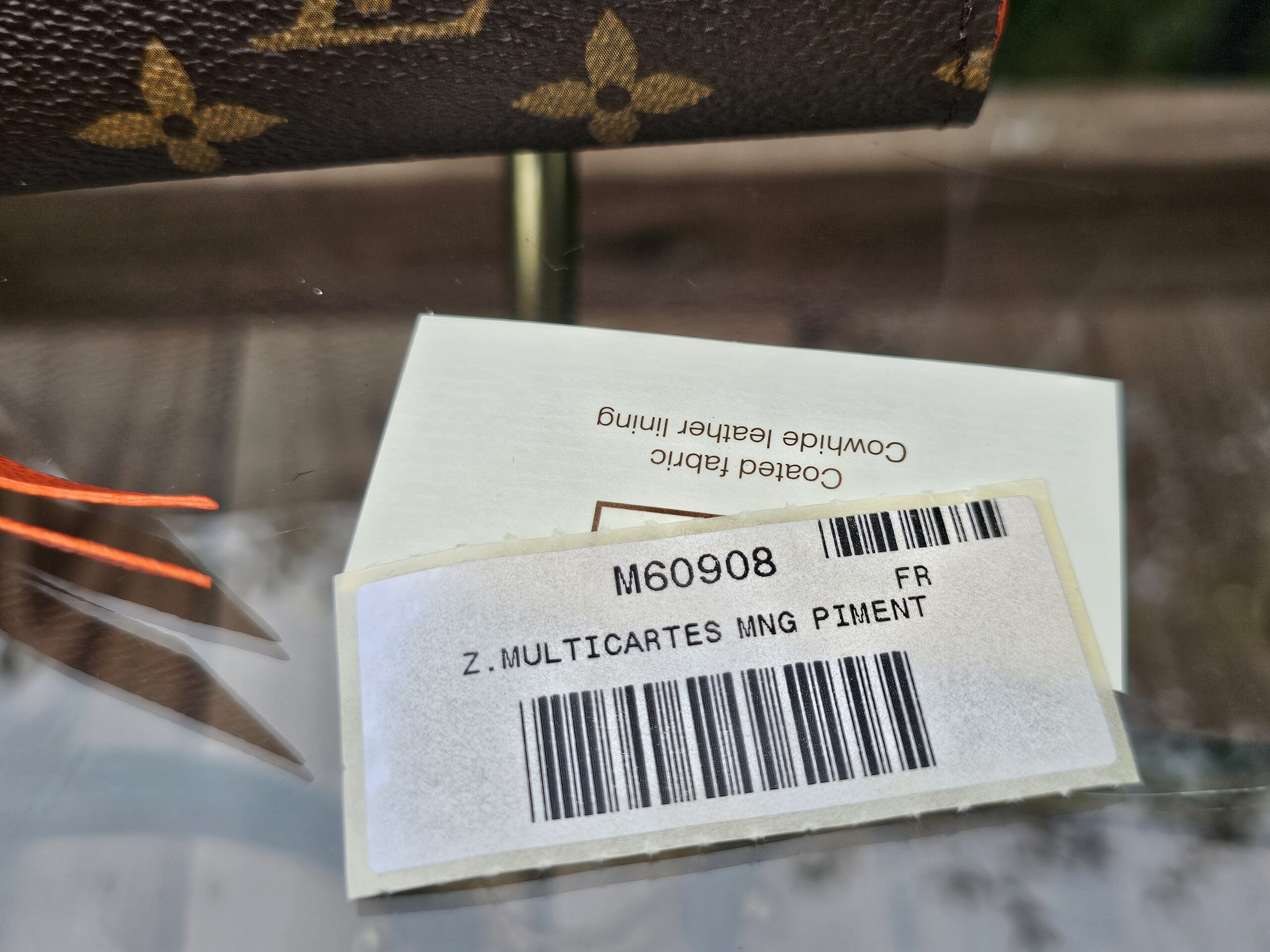 Retail tag for the Louis Vuitton Zippy Multicartes reading Z MULTICARTES MNG PIMENT with style M60908
