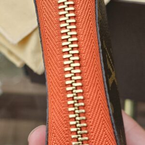 Side profile of the Louis Vuitton Zippy Multicartes showing the orange leather trim