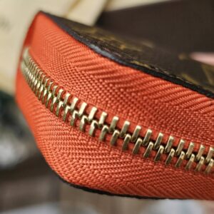 Close-up of the gold-tone zip hardware on the Louis Vuitton Zippy Multicartes