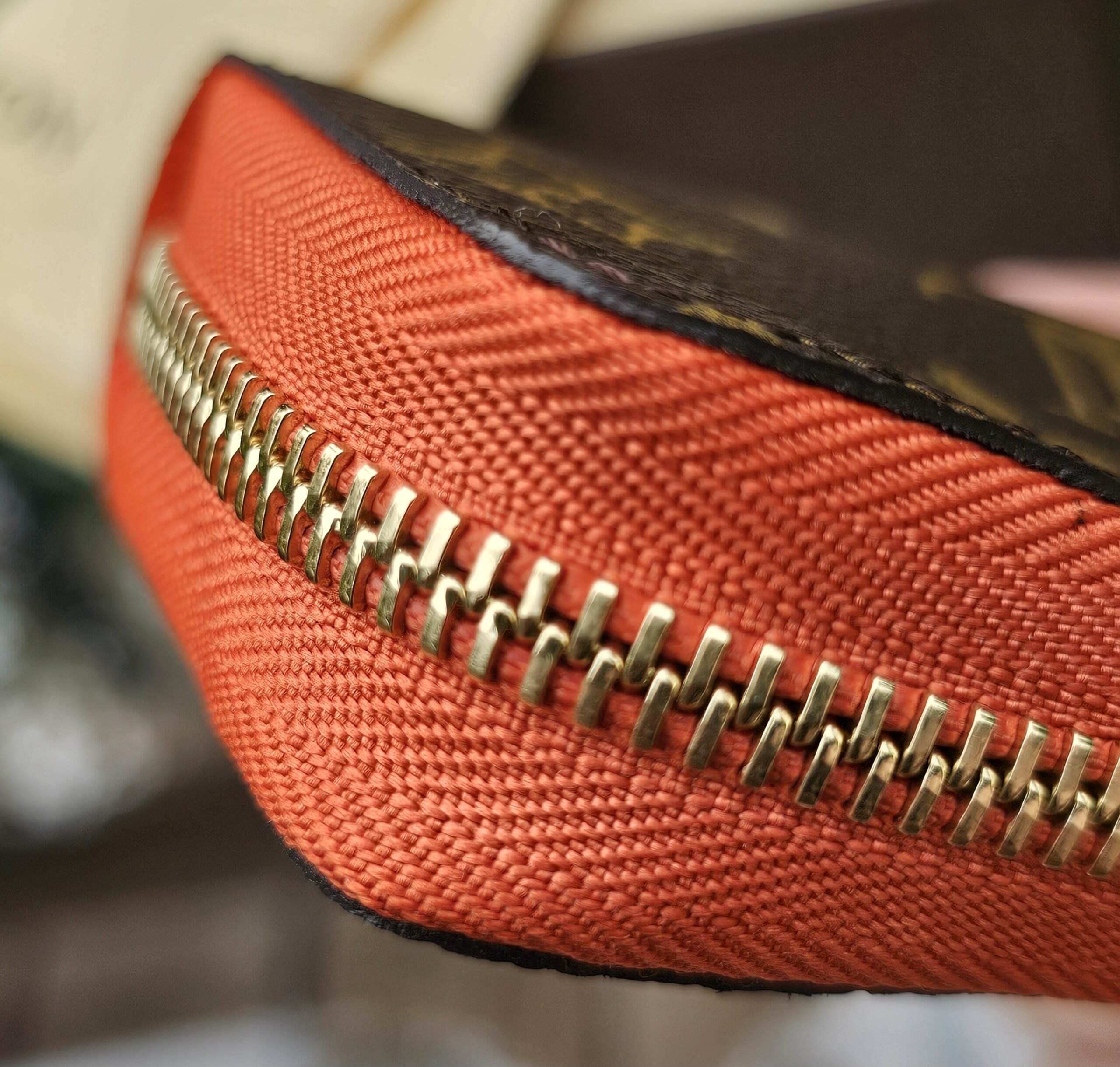 Close-up of the gold-tone zip hardware on the Louis Vuitton Zippy Multicartes
