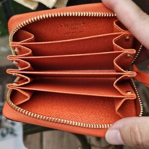 Open card compartments of the Louis Vuitton Zippy Multicartes in vibrant Piment orange
