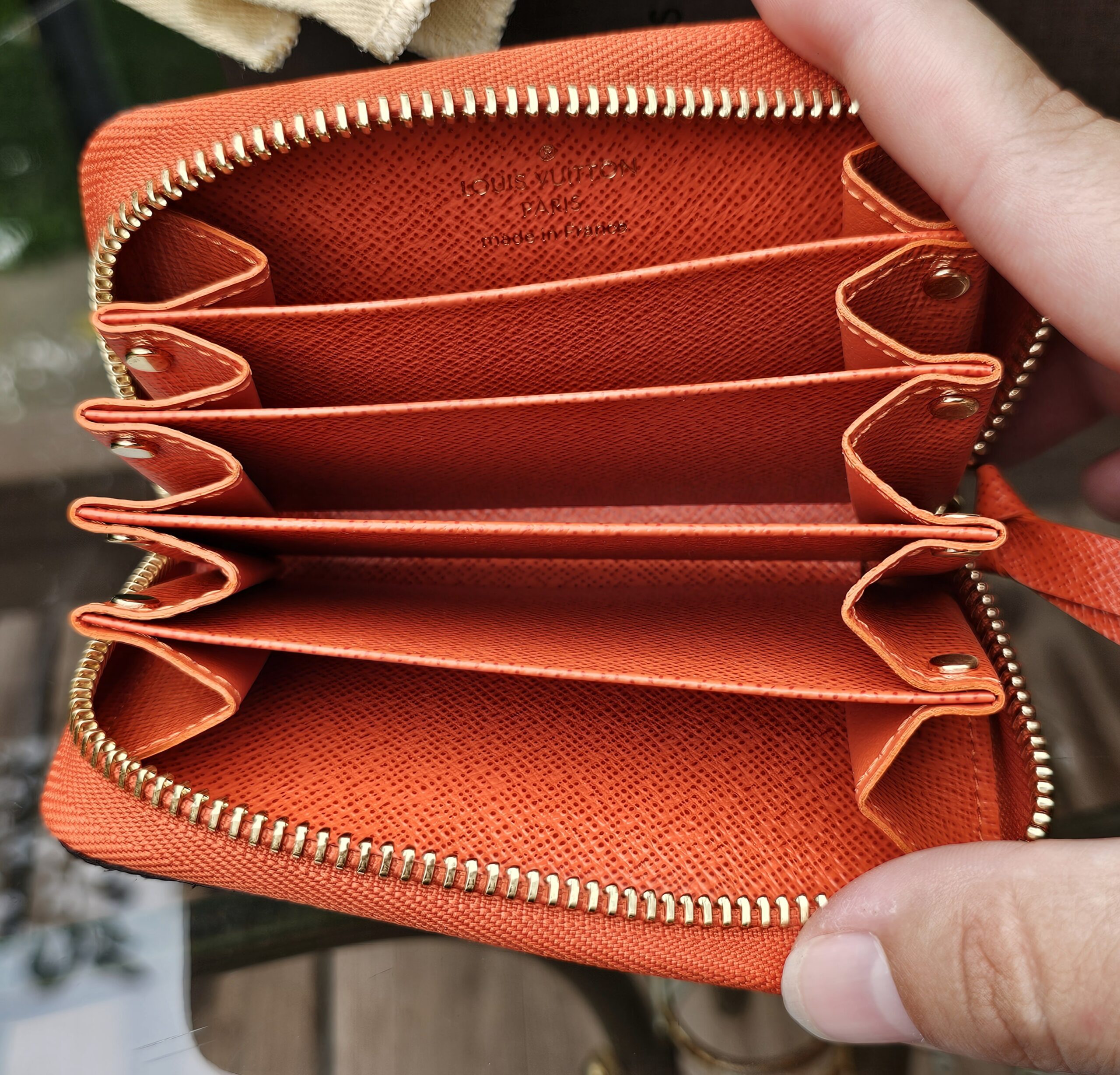Open card compartments of the Louis Vuitton Zippy Multicartes in vibrant Piment orange