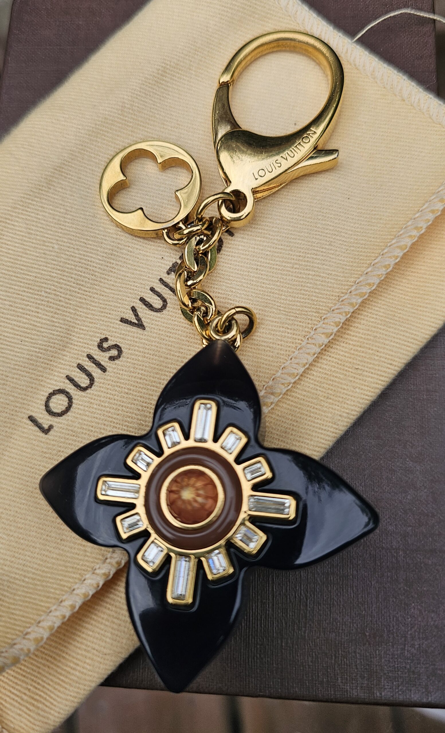 Gold-tone lobster clasp and LV flower ring on the Fleur d Etoile bag charm
