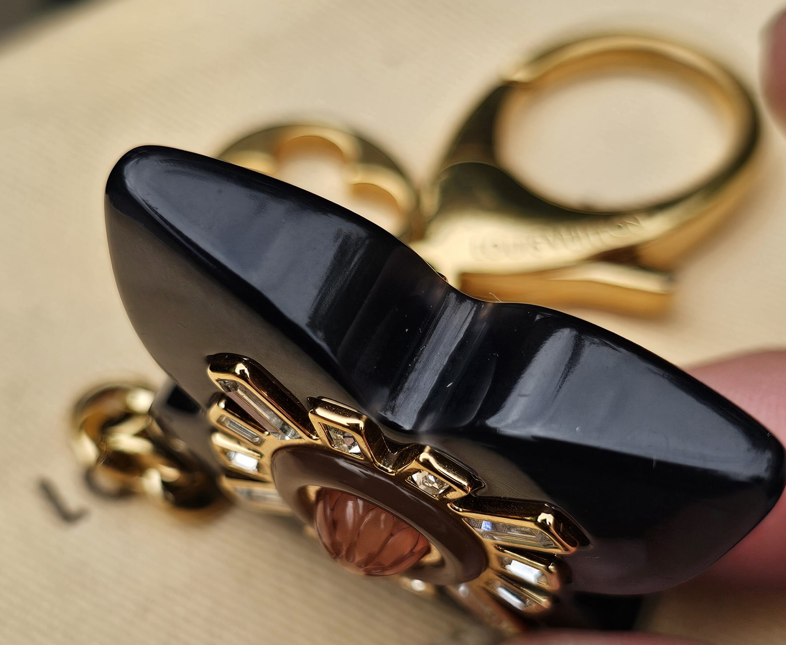 Side profile of the glossy black resin flower on the Louis Vuitton Fleur d Etoile charm