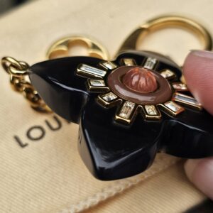 Louis Vuitton Fleur d Etoile bag charm held in hand to show scale
