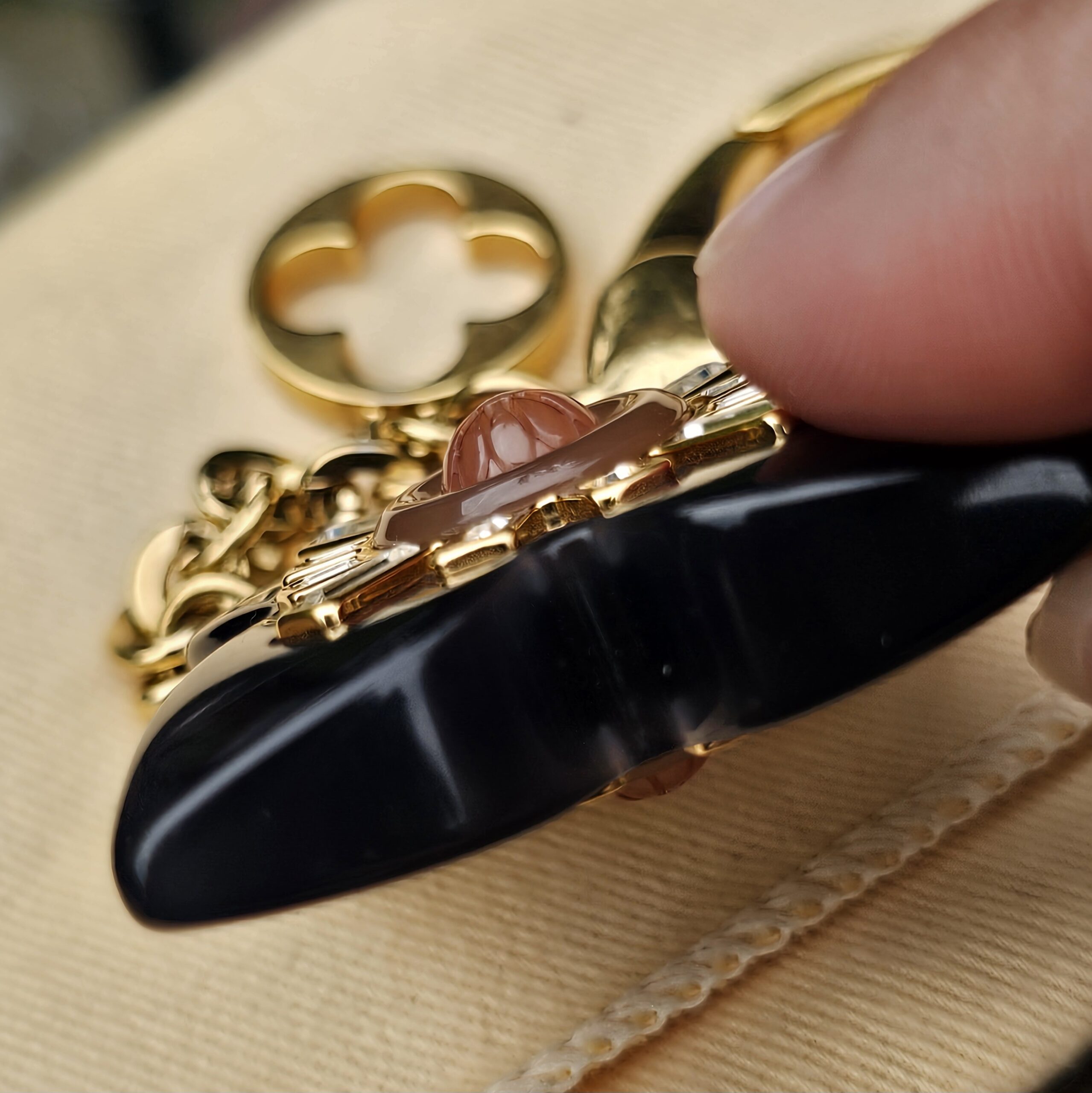 Edge of the black resin flower and gold-tone setting on the Louis Vuitton Fleur d Etoile charm