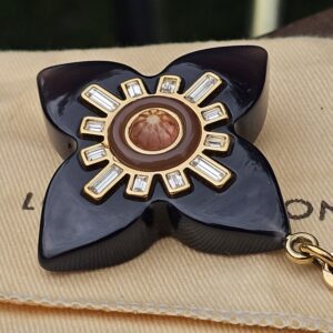 Louis Vuitton Fleur d Etoile charm resting on its Louis Vuitton dust bag