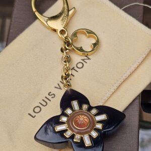 Full view of the Louis Vuitton Fleur d Etoile key holder and bag charm with chain and clasp