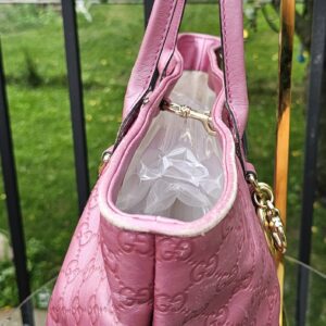 Side profile of the Gucci Guccissima Large Heart Bit tote in pink