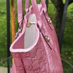 Side of the pink Guccissima Heart Bit tote showing the embossed GG pattern