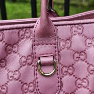 Gold-tone D-ring handle attachment on the pink Guccissima Heart Bit tote
