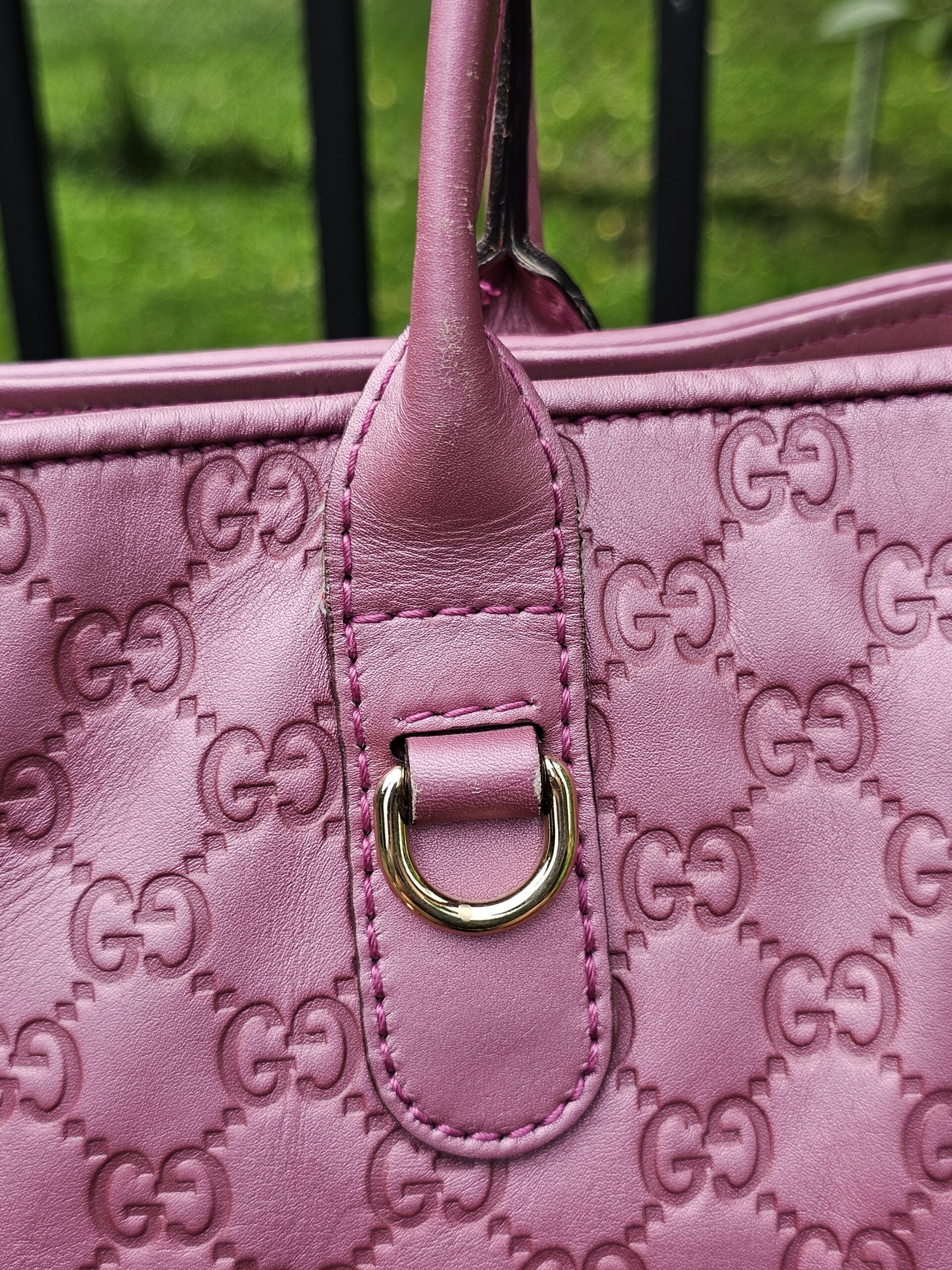 Gold-tone D-ring handle attachment on the pink Guccissima Heart Bit tote