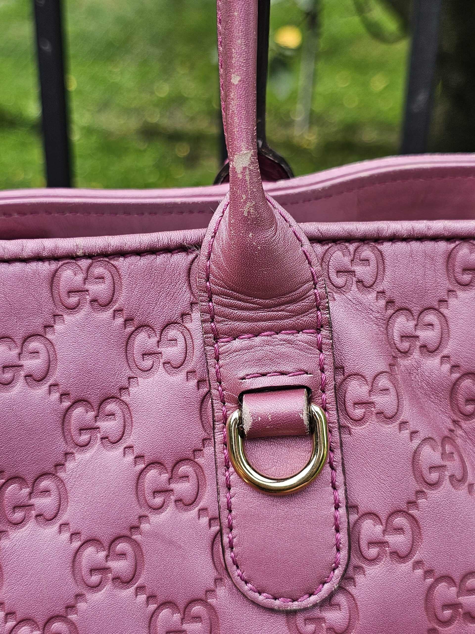Base of the leather handle where it meets the pink Guccissima tote body