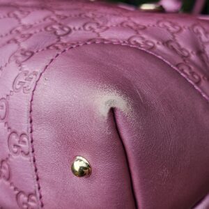 Corner of the pink Guccissima tote showing rubbing and colour loss from use