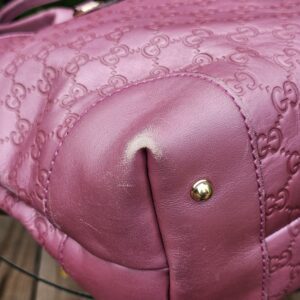 Bottom corner and metal foot of the Gucci Heart Bit tote shown for condition