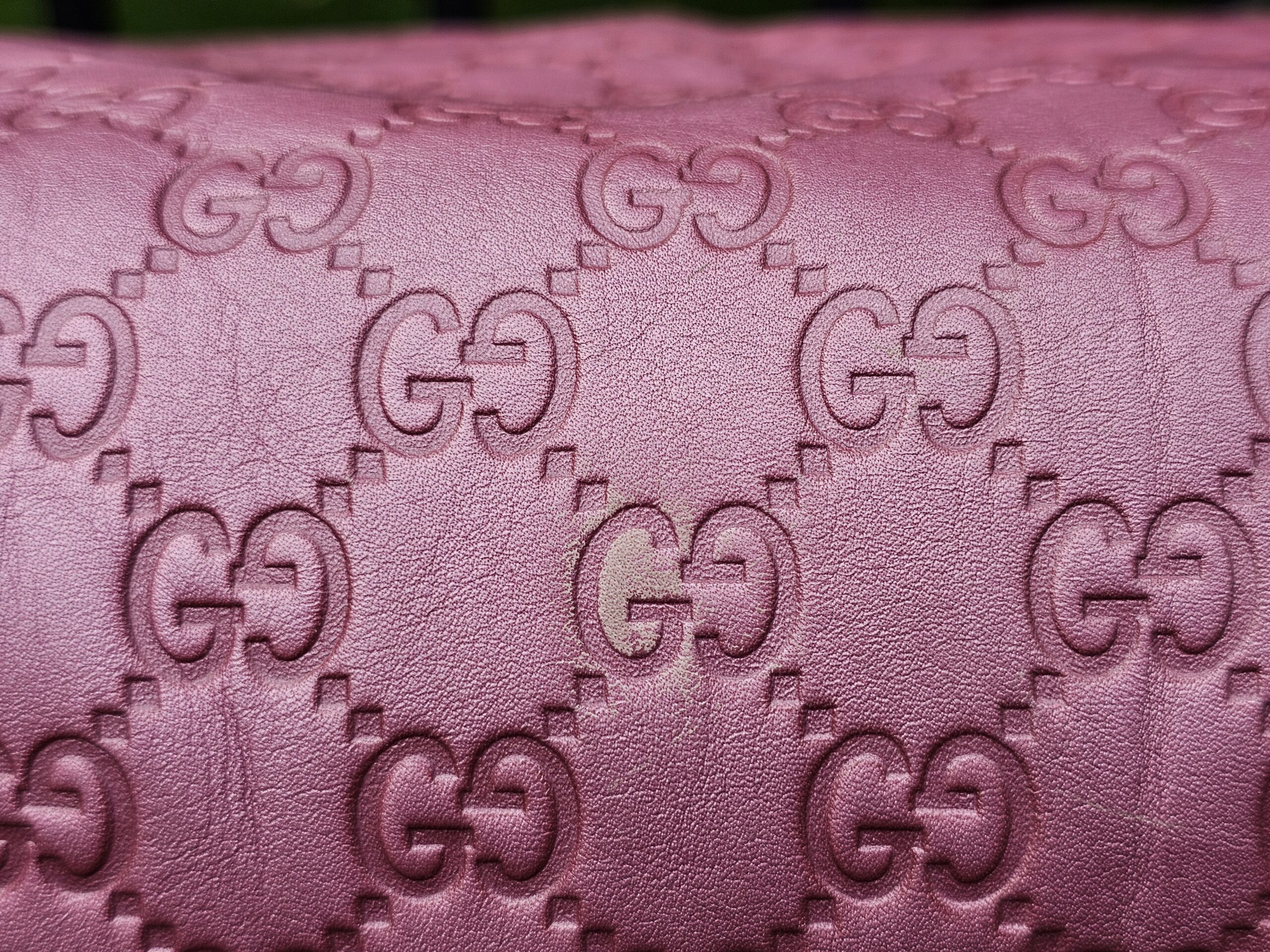 Close-up of the embossed GG Guccissima pattern in pink leather