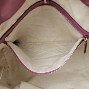 Interior zip pocket of the Gucci Heart Bit tote held open