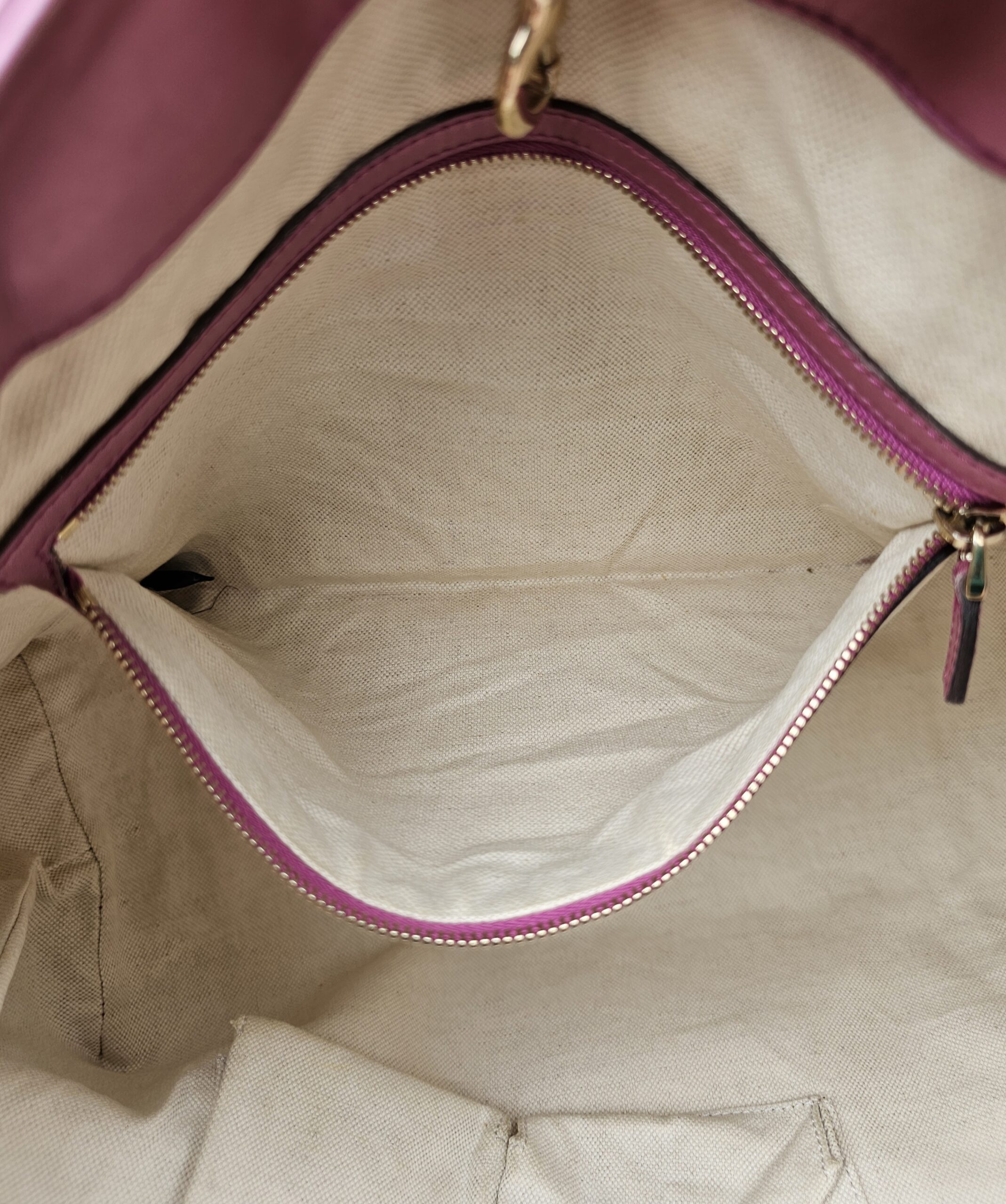 Interior zip pocket of the Gucci Heart Bit tote held open
