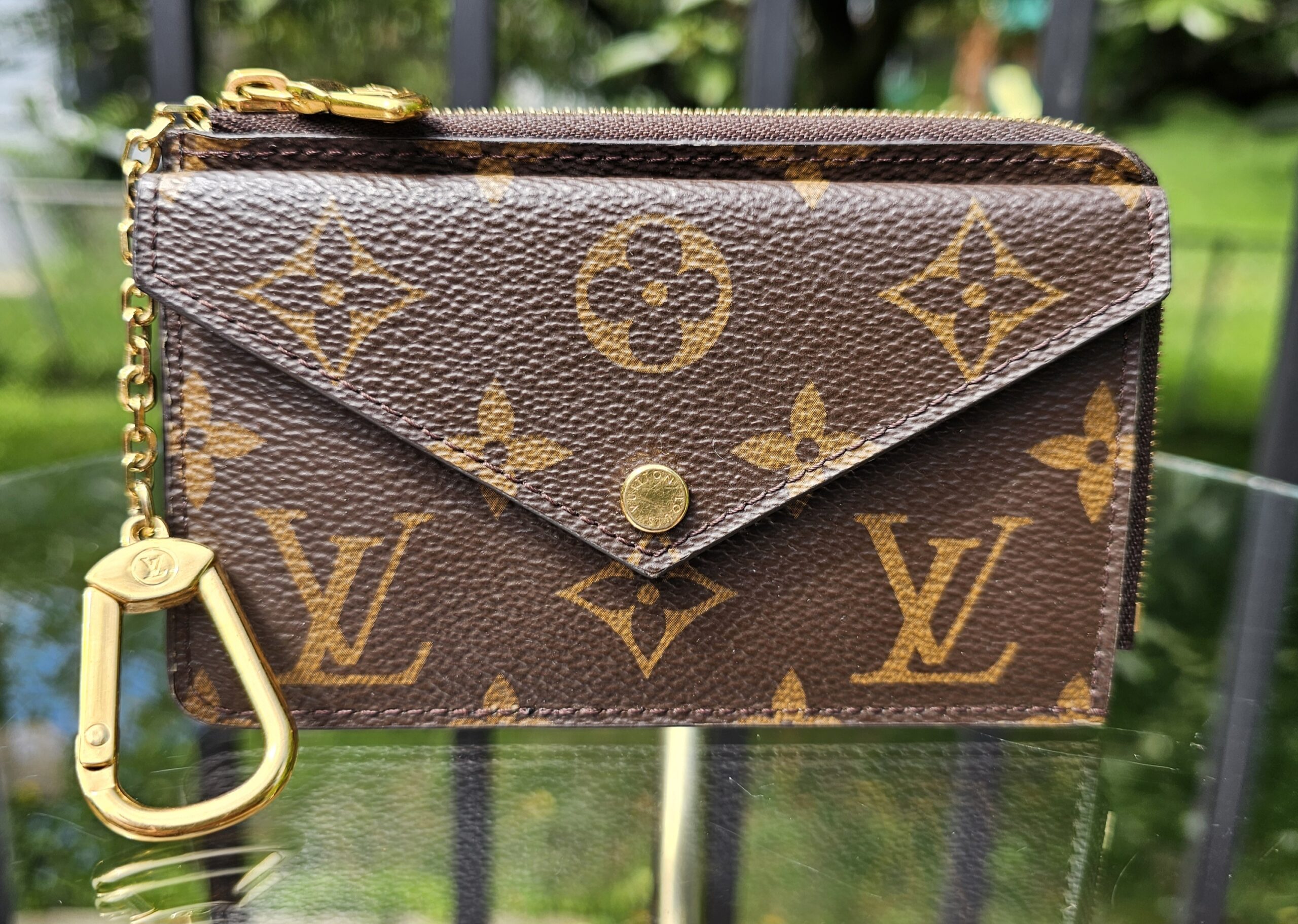 Louis Vuitton Monogram Recto Verso card holder showing the envelope snap flap in Monogram coated canvas with a gold key clip