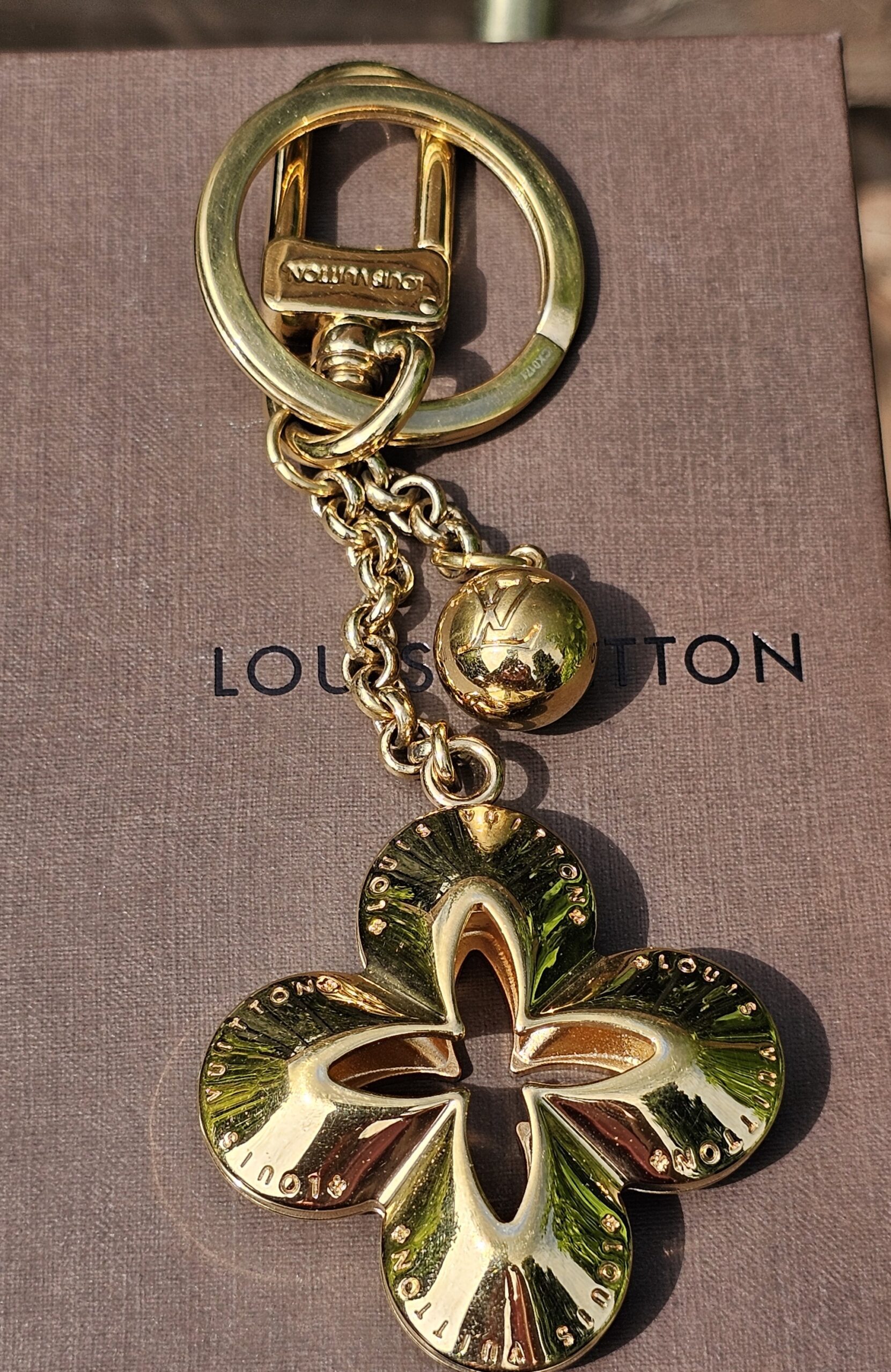 Louis Vuitton Eclipse key holder and bag charm in gold-tone metal with the Monogram flower charm and LV sphere