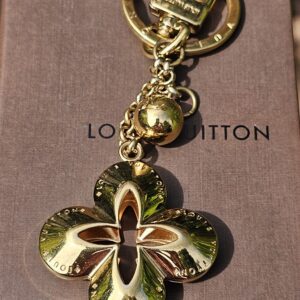 Full length of the Louis Vuitton Eclipse gold-tone key holder and bag charm showing the ring, chain and flower charm