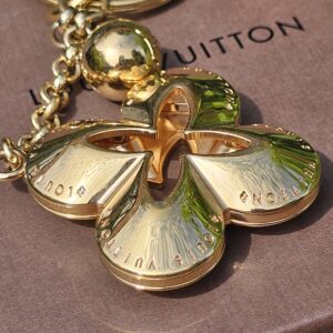 Louis Vuitton engraved across the petals of the Eclipse gold-tone flower charm