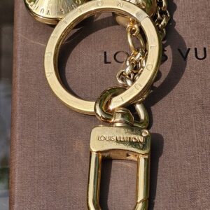 Gold-tone lobster clasp stamped Louis Vuitton on the Eclipse key holder and bag charm