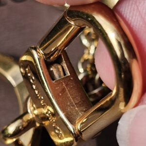 Open clasp mechanism of the Louis Vuitton Eclipse gold-tone key holder and bag charm