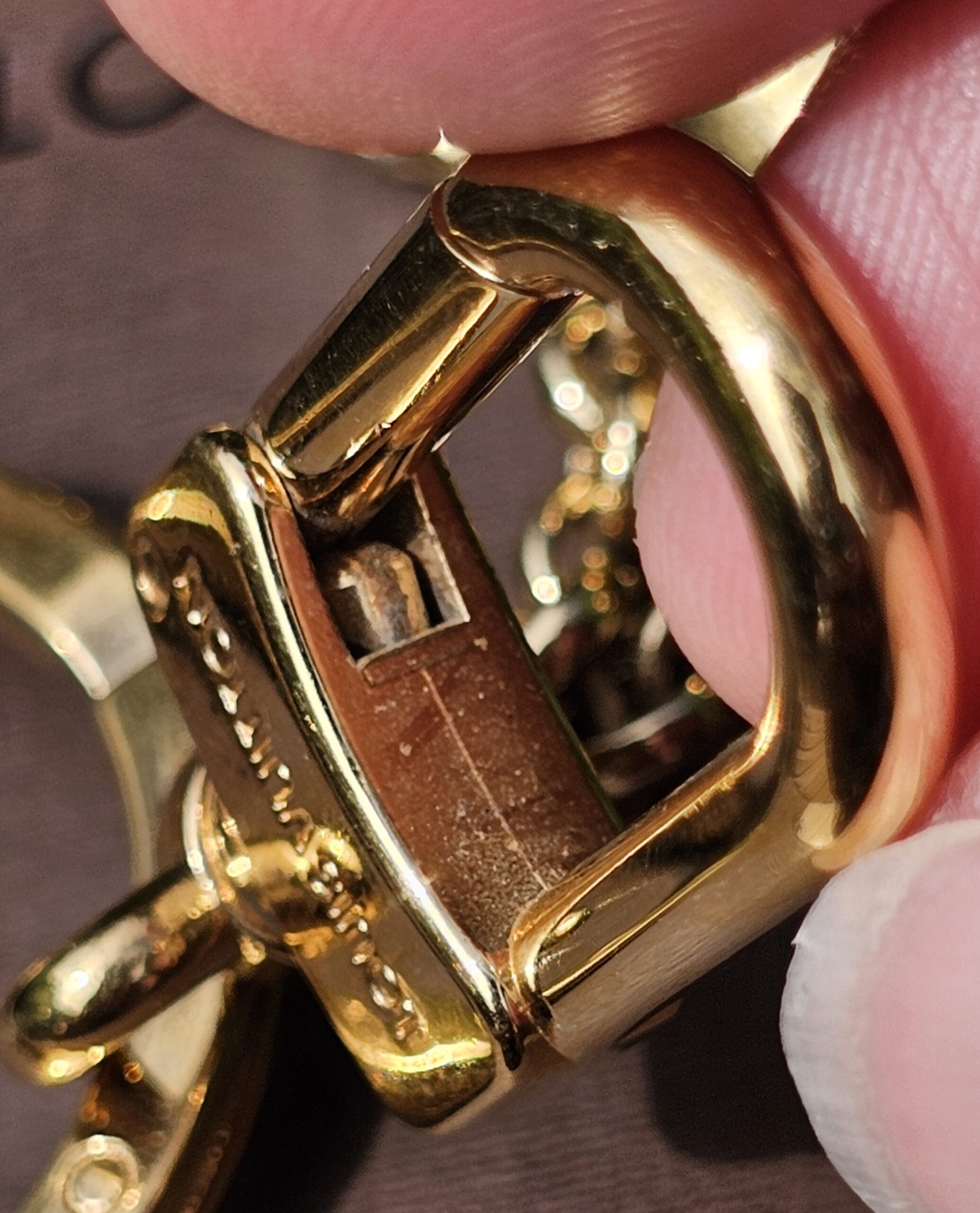 Open clasp mechanism of the Louis Vuitton Eclipse gold-tone key holder and bag charm