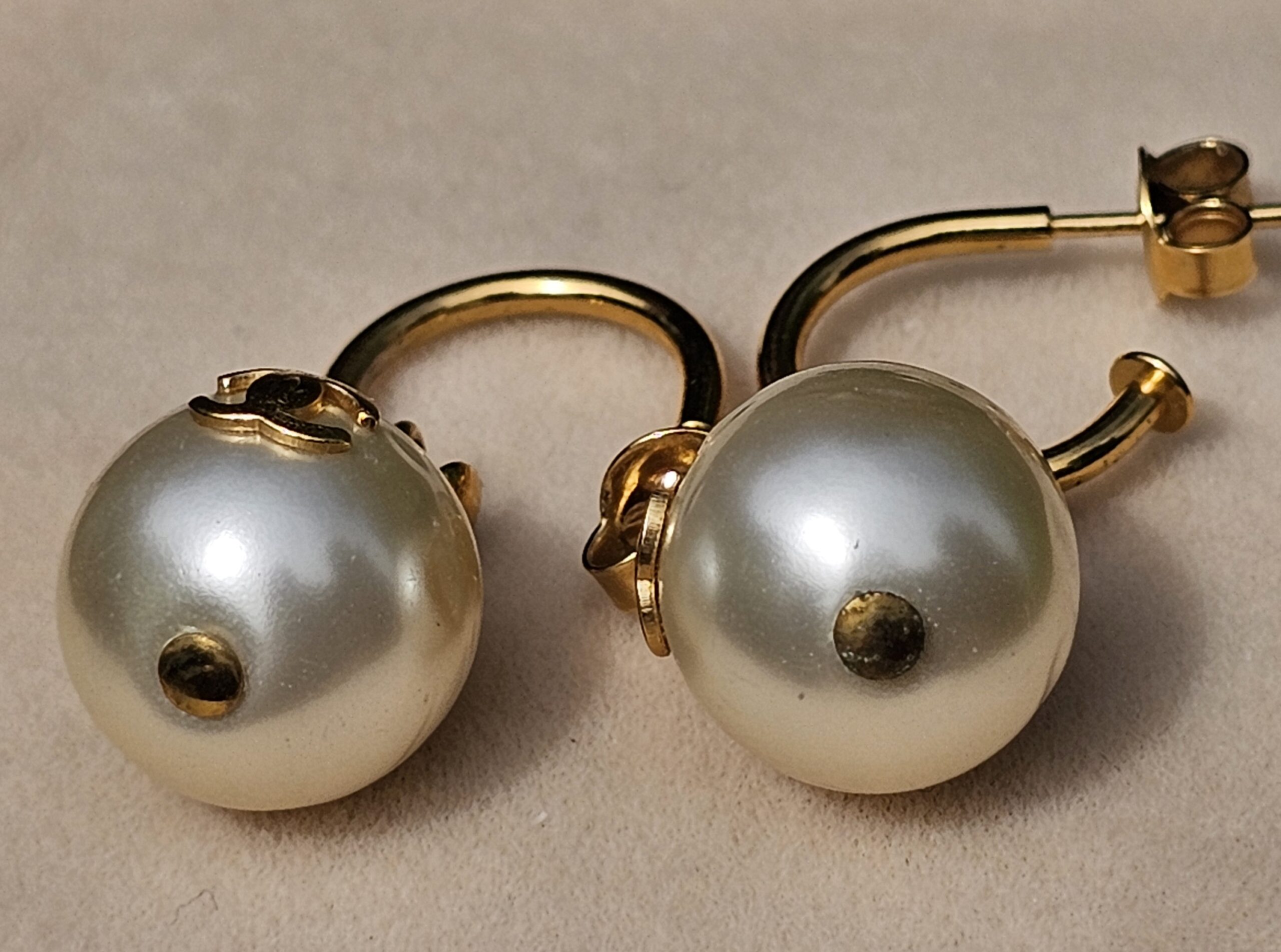 Chanel faux pearl drop earrings showing the gold-tone hoop design and pearl drops