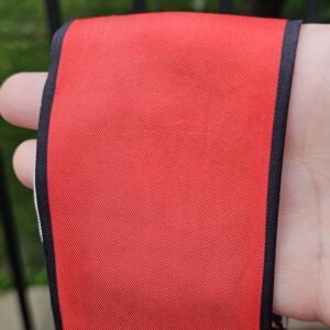 Close-up of the red silk on the Louis Vuitton Trunks bandeau held in hand
