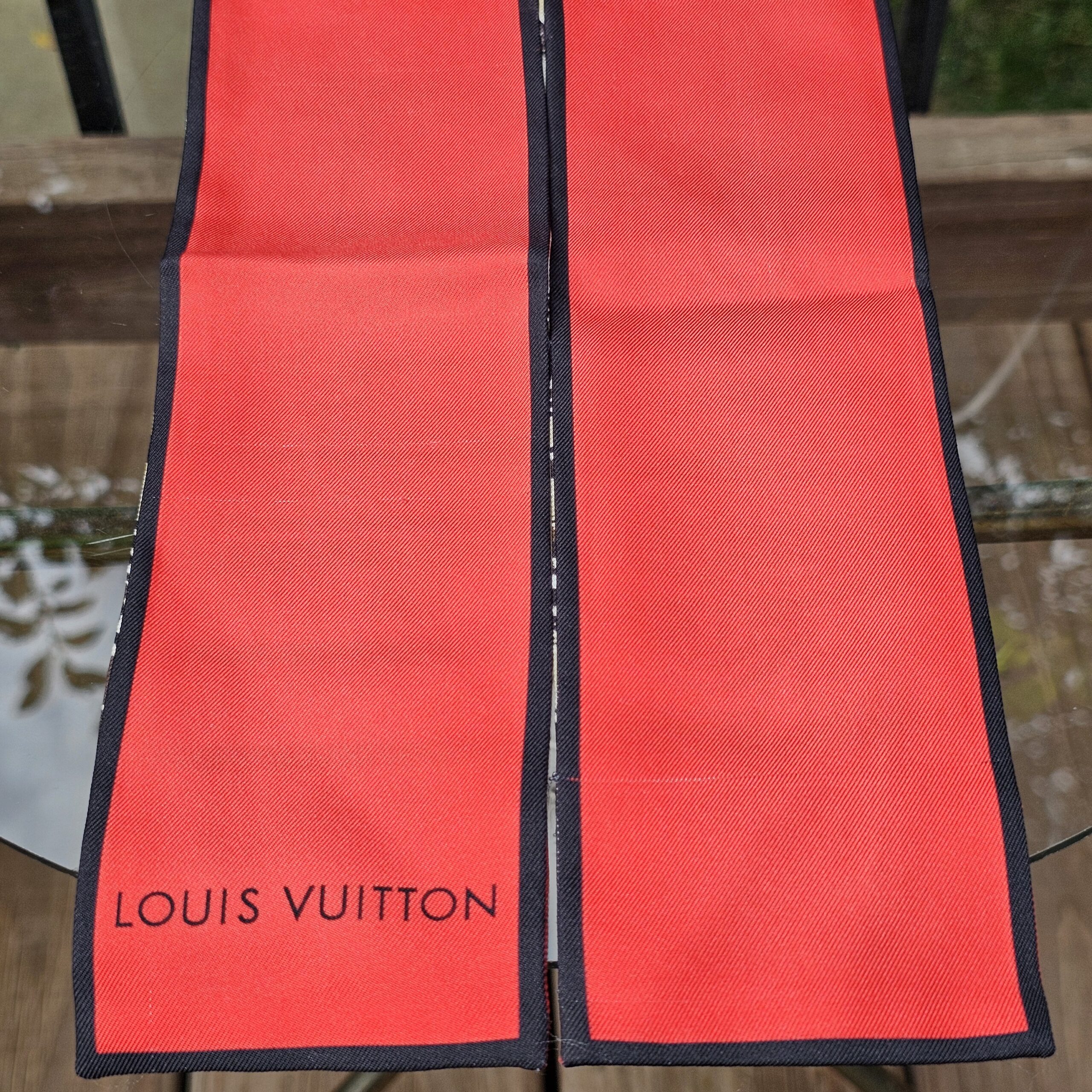 Louis Vuitton printed on the red end panel of the silk Monogram Trunks bandeau