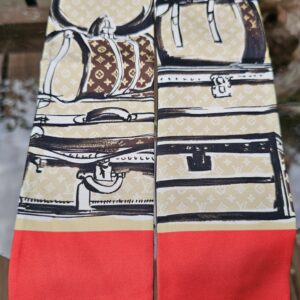 Stacked luggage illustrations and red panel on the Louis Vuitton silk Trunks bandeau