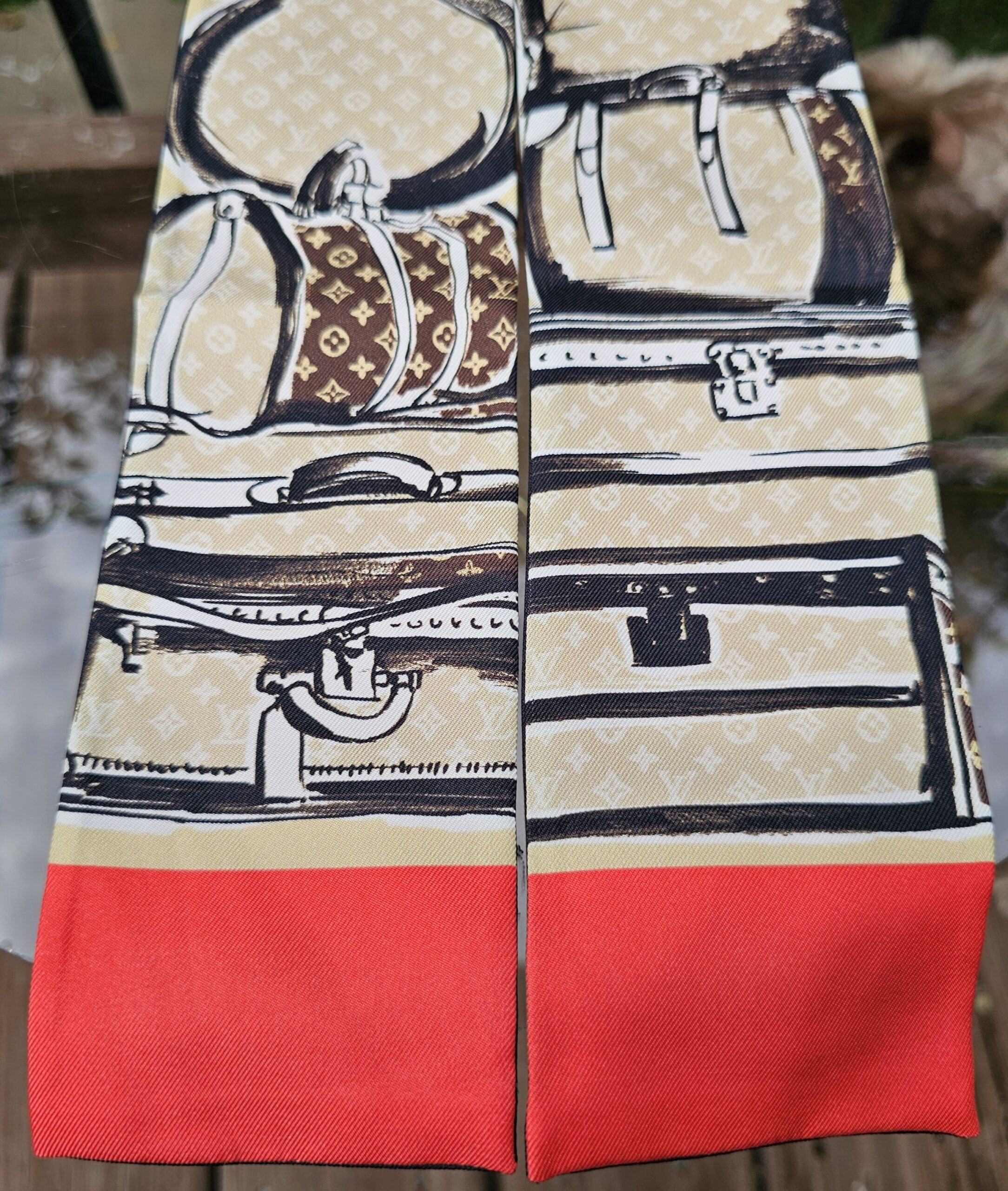 Stacked luggage illustrations and red panel on the Louis Vuitton silk Trunks bandeau