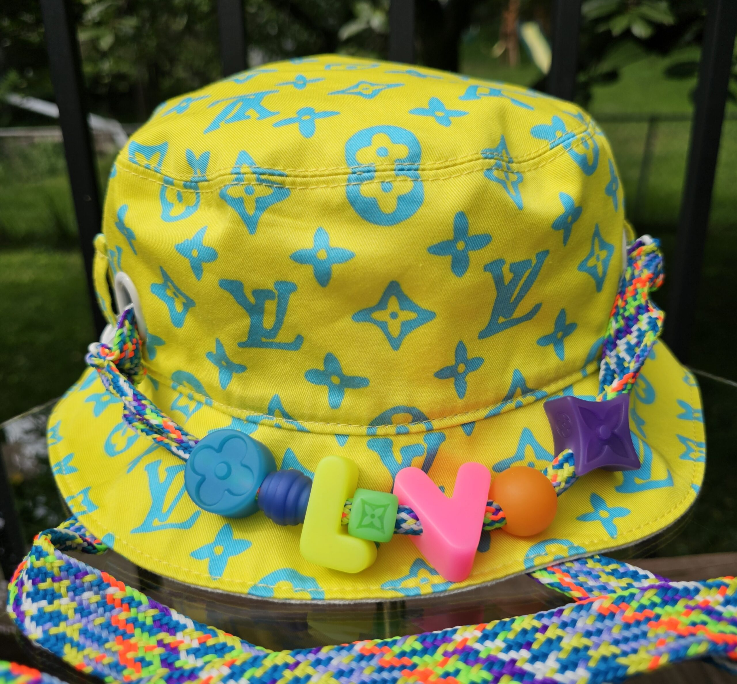 Front of the Louis Vuitton Virgil Abloh bucket hat showing the blue Monogram print on yellow cotton and the beaded cord