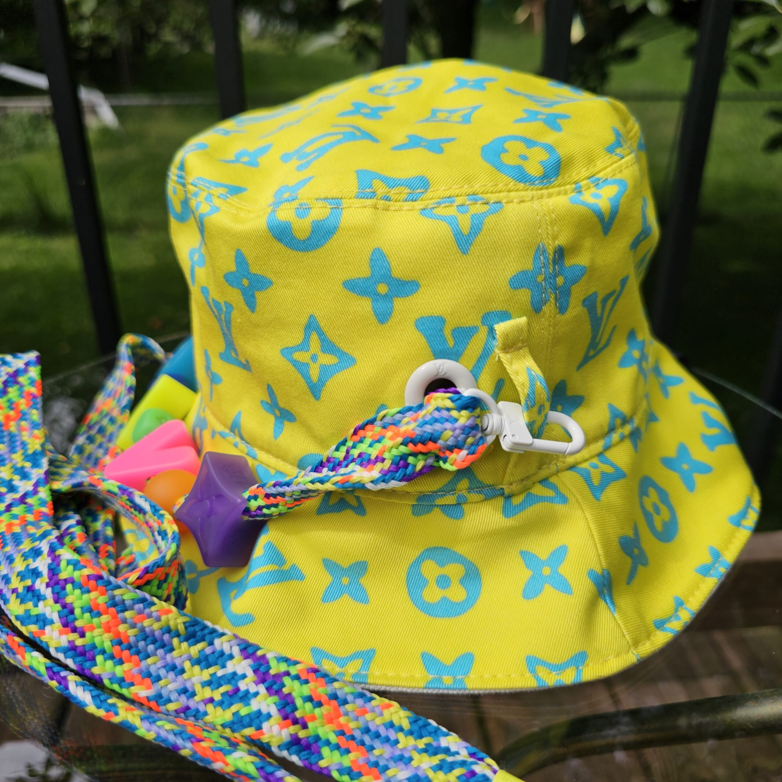 Side view of the yellow Louis Vuitton Virgil Abloh bucket hat with the multicolor braided cord