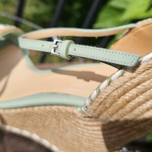 Heel and ankle strap of the Gucci mint green espadrille wedge sandal against the jute wedge