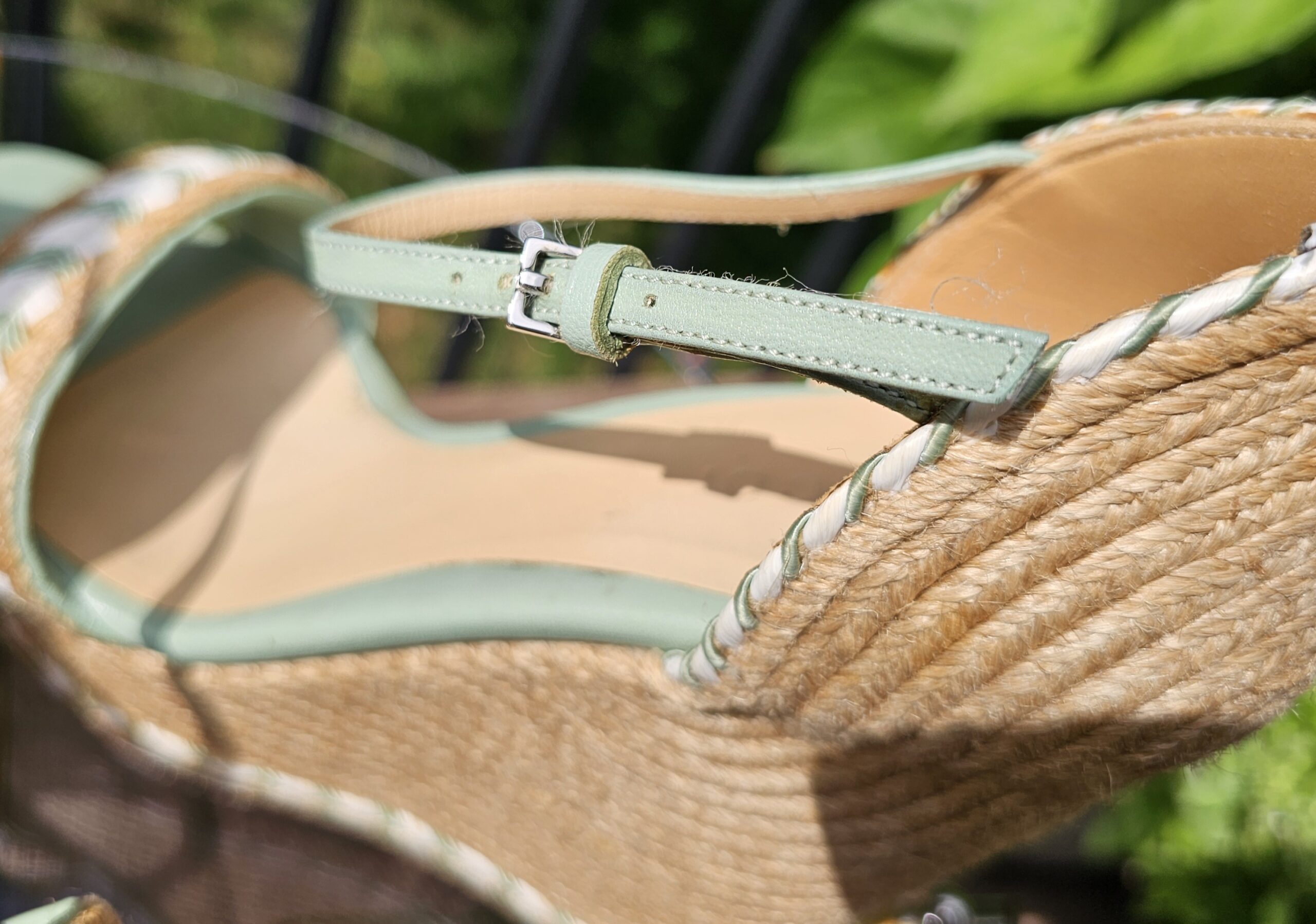 Heel and ankle strap of the Gucci mint green espadrille wedge sandal against the jute wedge