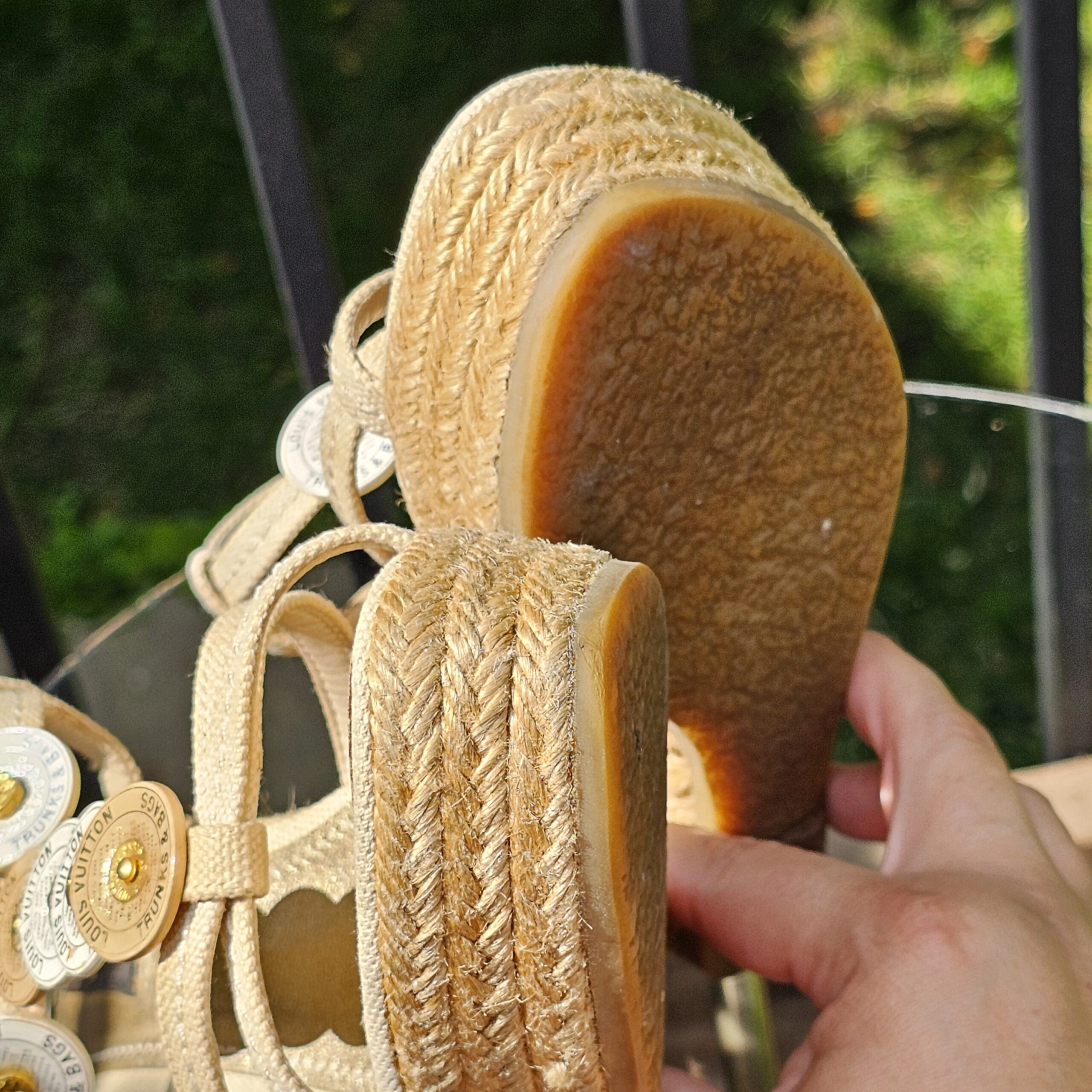 Sole and woven jute wedge of the Louis Vuitton Trunks and Bags espadrille sandal held in hand