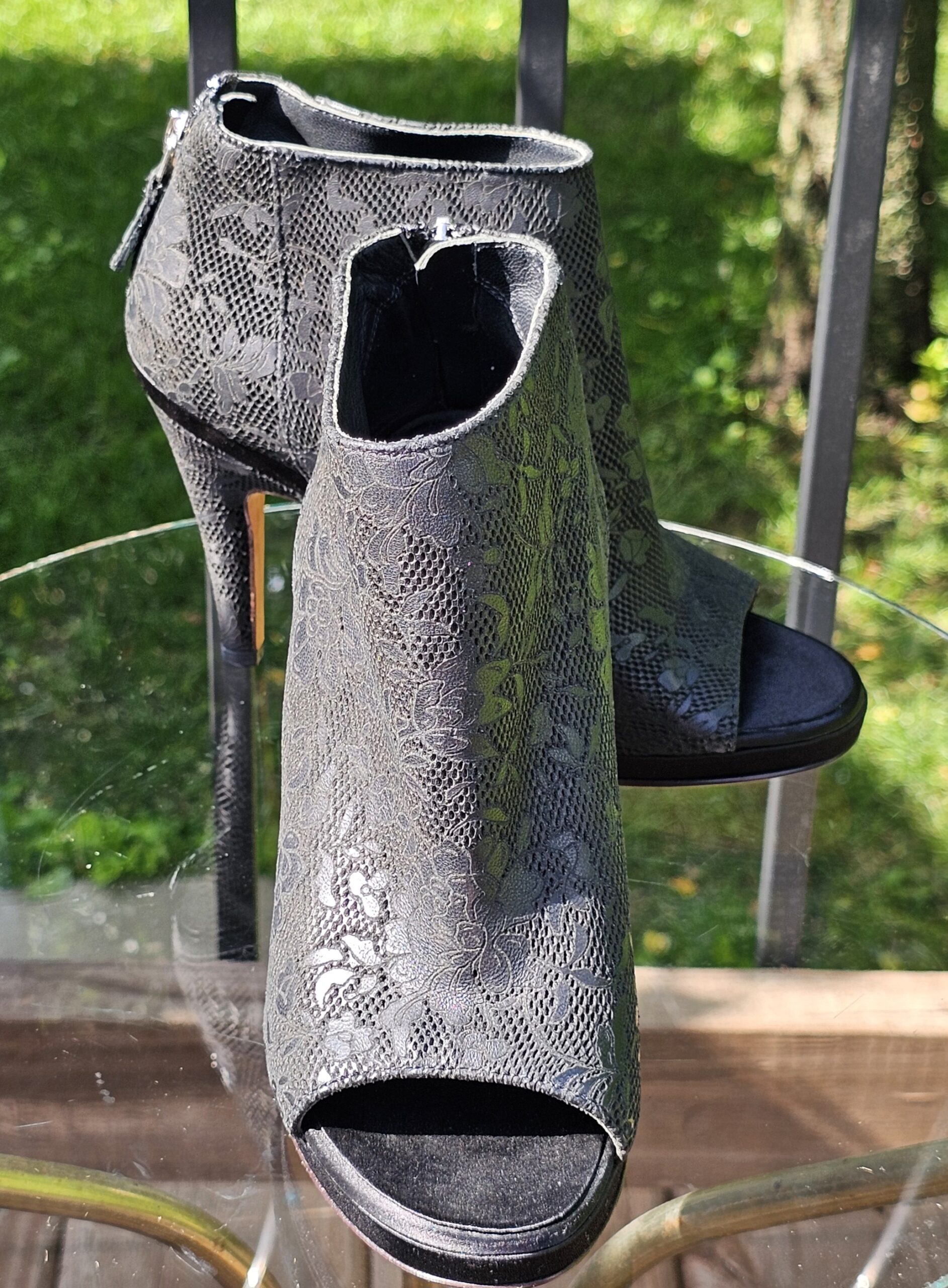Chanel peep toe ankle bootie in black lace-pattern leather with a slim heel