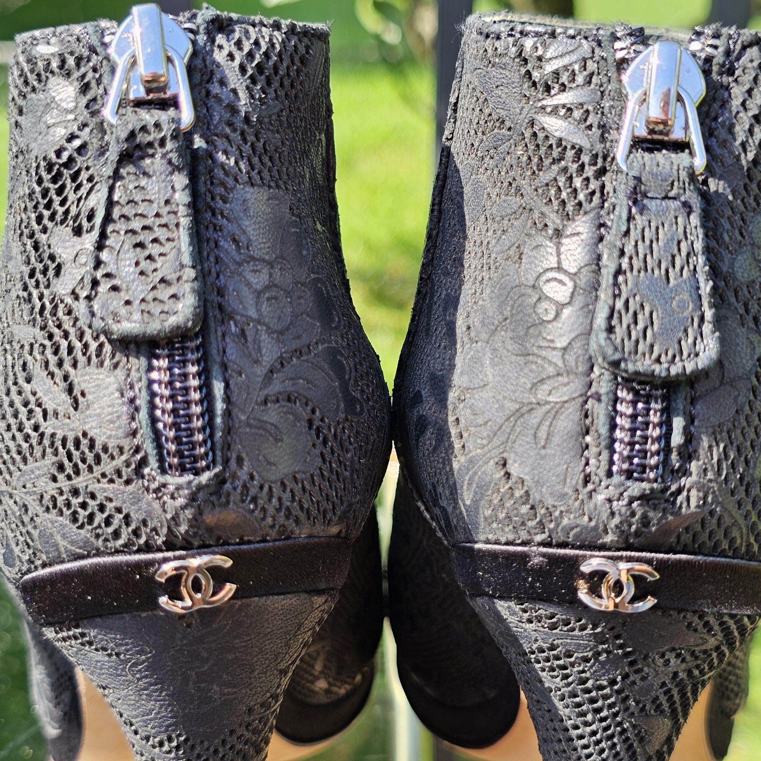Close-up of the silver-tone CC logos at the back heels of the Chanel lace peep toe ankle booties