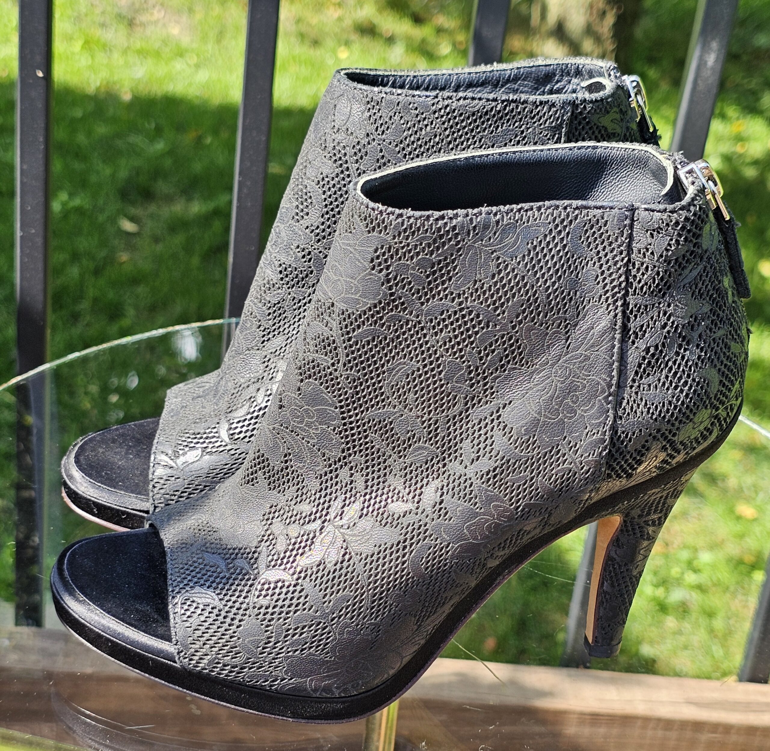 Side profile of the Chanel lace-pattern peep toe ankle bootie showing the heel height