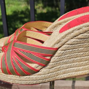 Pair of Christian Louboutin espadrille wedge sandals shown from the side with striped woven straps