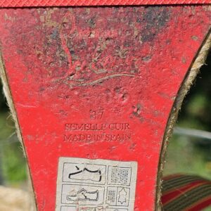 Close-up of the red sole of the Christian Louboutin espadrille wedge sandals reading Semelle Cuir Made in Spain