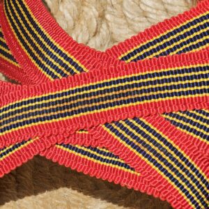 Close-up of the red, navy and yellow striped woven straps on the Christian Louboutin espadrille wedge sandals