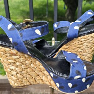 Adjustable printed ankle straps and gold-tone buckles on the Louis Vuitton raffia wedge sandals
