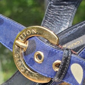 Gold-tone buckle engraved Louis Vuitton on the ankle strap of the printed raffia wedge sandals